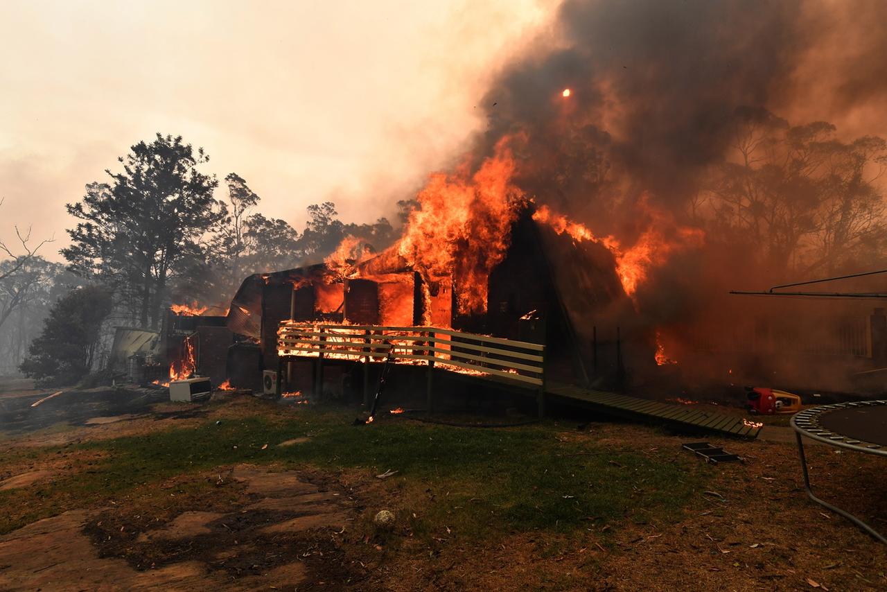 Une maison détruite par le feu à Buxton, au sud-ouest de Sydney. [Keystone - EPA/Dean Lewins]