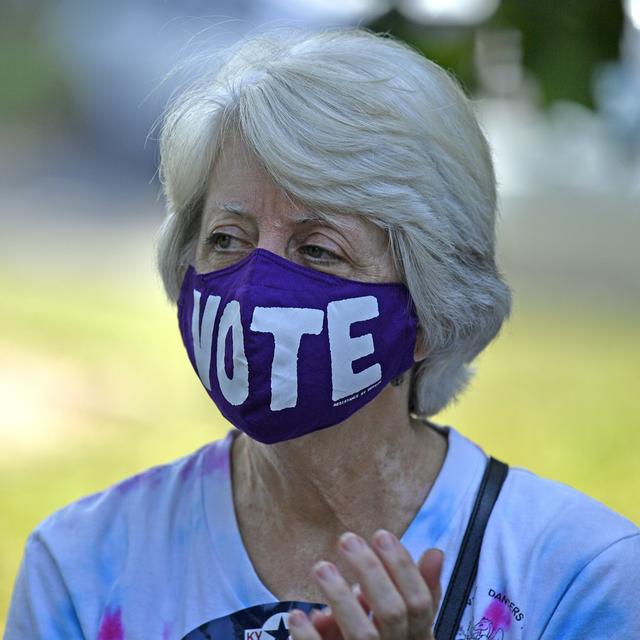 Une femme américaine portant un masque appelant à voter. [Keystone/AP Photo - Timothy D. Easley]