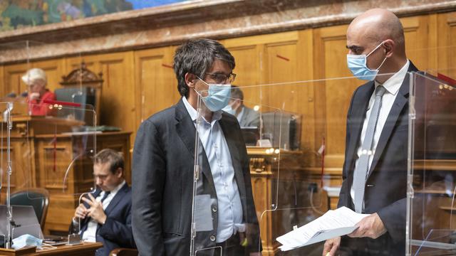 Alain Berset, conseiller fédéral en charge de de la Santé, discute avec le socialiste Roger Nordmann (VD) lors de la session du Conseil national le 29 octobre. [Keystone - Alessandro della Valle]