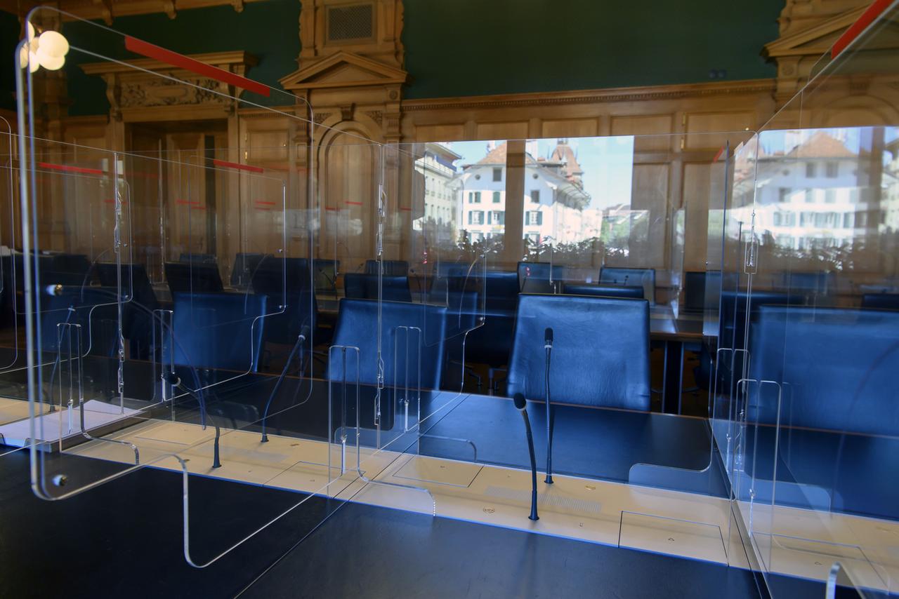 Du plexiglas sépare les différentes places de travail dans une salle de commission. Le bâtiment du Parlement est en cours de préparation pour la session d'automne, avec le coronavirus. Berne, le 20 août 2020. [Keystone - Anthony Anex]