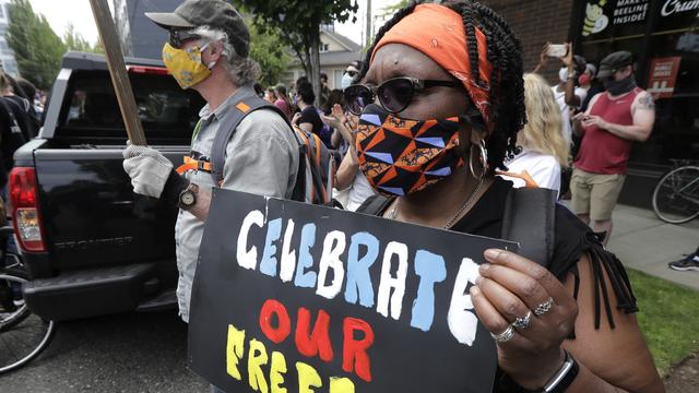 Des personnes célébrant à Seattle le 19 juin 2020 le "Juneteenth" (contraction de juin et de 19 en anglais), qui marque le jour de 1865 où les derniers esclaves ont été libérés au Texas. [Keystone - AP Photo/Ted S. Warren]