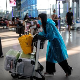 Des voyageurs dans l'aéroport de Bangkok, en Thaïlande, tentent de trouver un vol alors que la plupart sont annulés. [AFP - Jack TAYLOR]