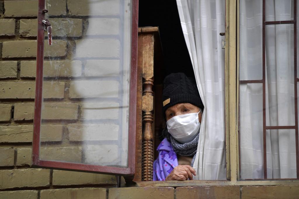 Une personne âgée regarde par la fenêtre dans le quartier de Kennedy, une des zones de Bogota qui connaît un grand nombre de contaminations au Covid-19. Colombie, le 3 juin 2020. [AFP - Raul Arboleda]