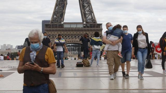 Des touristes masqués devant la tour Eiffel, le 27 août 2020. [AFP - Mehdi Taamallah]