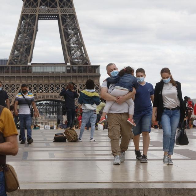 Des touristes masqués devant la tour Eiffel, le 27 août 2020. [AFP - Mehdi Taamallah]