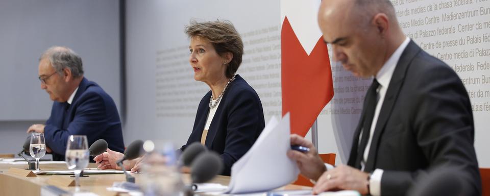 De gauche à droite, les conseillers fédéraux Guy Parmelin, Simonetta Sommaruga (présidente de la Confédération) et Alain Berset, lors de la première conférence de presse du mercredi 29 avril 2020. [Keystone - Peter Klaunzer]