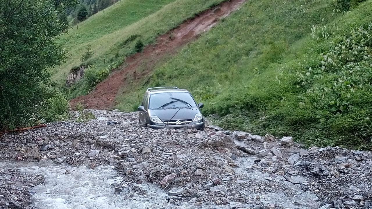 Un véhicule bloqué par une lave torrentielle sur un passage à gué de la vallée de l’Oberbach, à Jaun (FR). [Police fribourgeoise]