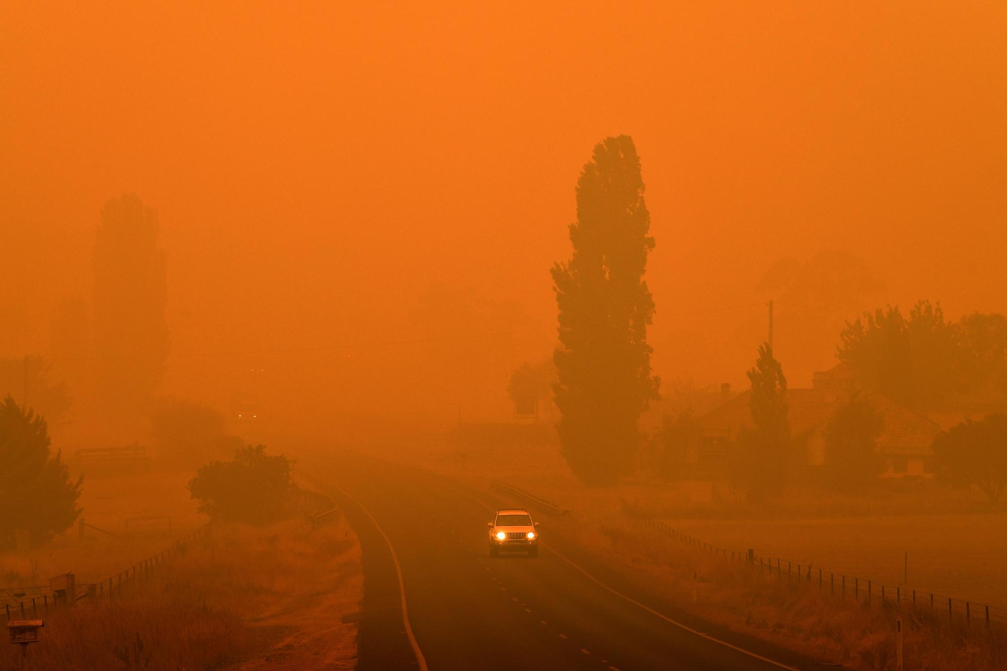 Une route envahie par une épaisse fumée à Bemboka, dans le sud-est du pays. [Keystone - Saeed Khan]