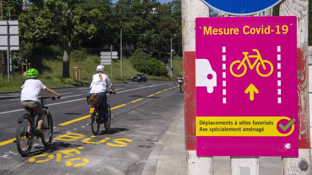 Le Conseil d'Etat genevois a modifié ou a crée de nouvelles pistes cyclables et mise sur la mobilité douce pour faire face au Covid-19. Le vélo et la marche permettent de garder ses distances sociales. Genève, 21 mai 2020. [Keystone - Martial Trezzini]