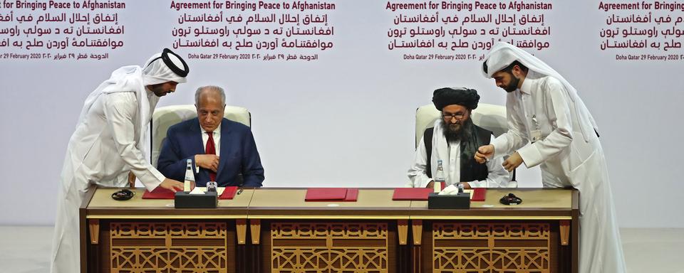 Les représentants américain et taliban lors de la signature du document à Doha, 29.02.2020. [AFP - Karim Jaafar]