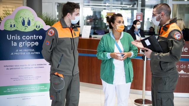 Des membres de la protection civile mobilisés à l'hôpital de Morges le 20 mars 2020. [Jean-Christophe Bott - Keystone]