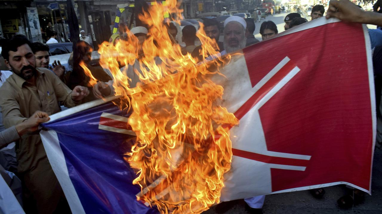 Des manifestants pakistanais brûlent un drapeau français. [Keystone/AP Photo - Muhammad Sajjad]