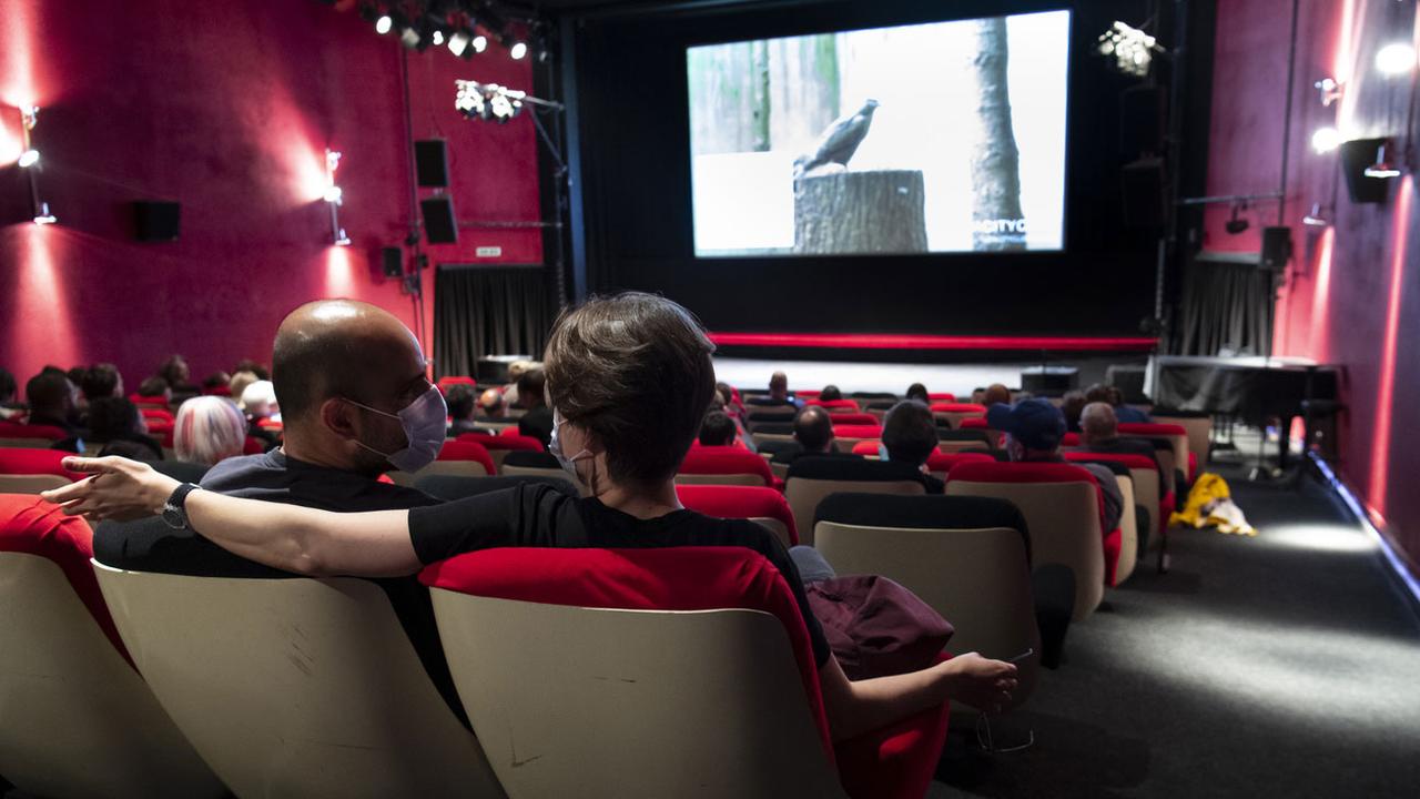 Des personnes s'installent pour visionner le film "L'île aux oiseaux" au Cinema City Club à Pully le jour de sa réouverture le 6 juin 2020. [Keystone - Laurent Gillieron]