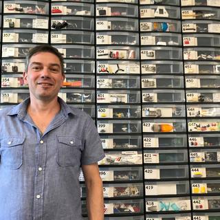 Christophe Durussel, fondateur de Brick Occasion SA, pose devant des centaines de tiroirs de pièces détachées de Lego. [RTS - Kim de Gottrau]