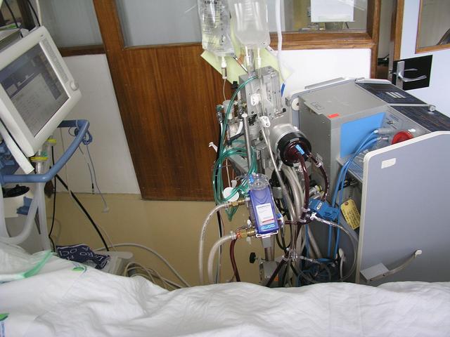 Un appareil d'ECMO (ExtraCorporeal Membrane Oxygenation), oxygénation par membrane extracorporelle. Le sang est oxygéné artificiellement par la machine avant d'être réinjecté dans le corps du patient. [CC - Cmenesesoliveira]