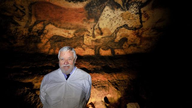 Le paléontologue français Yves Coppens pose devant des peintures dans la grotte de Lascaux, près du village de Montignac (sud-ouest de la France), à l'occasion du 70e anniversaire de sa redécouverte. [AFP - PHILIPPE WOJAZER / POOL]