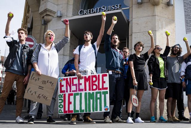 Des étudiants manifestent balle de tennis à la main, en référence au partenariat de Credit Suisse avec Roger Federer, contre les investissements de la banque dans des méthodes d'extraction du pétrole non-conventionnelles. Lausanne, le 24 mai 2019. [Keystone - Jean-Christophe Bott]