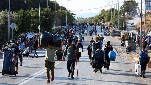 A Lesbos, la police évacue les réfugiés à la rue vers un nouveau camp. [Keystone/EPA - Vangelis Papantonis]