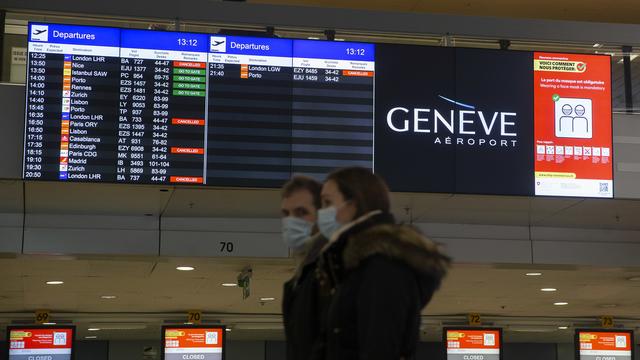 Des passagers à l'aéroport de Genève, devant des annonces de suppression de vols vers et depuis le Royaume-Uni et l'Afrique du Sud. [Keystone - Salvatore Di Nolfi]