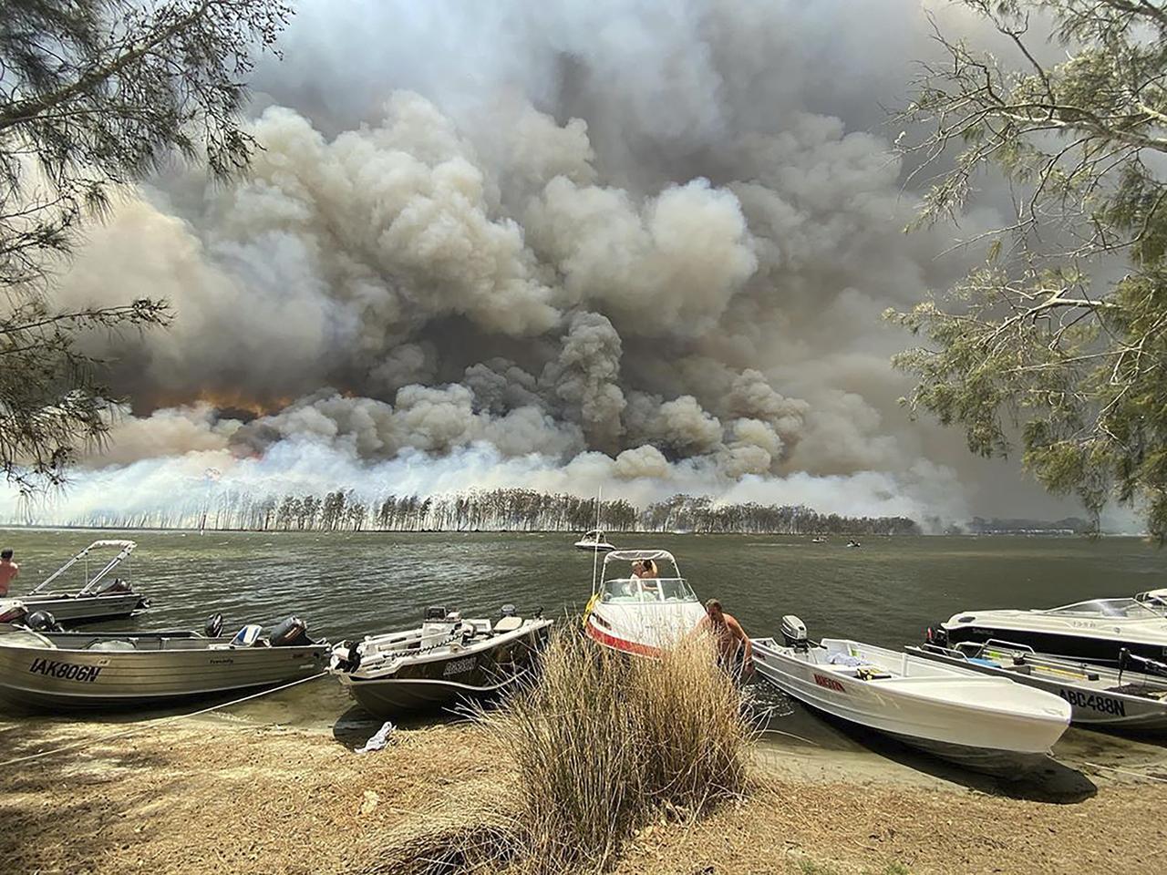 Un mur de fumée derrière le lac Conjola, sur la côte est. [Keystone - Robert Oerlemans via AP]