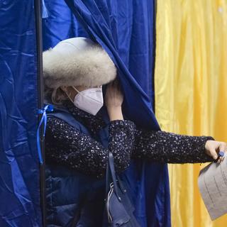 Une citoyenne roumaine dans un bureau de vote le 6 décembre 2020. [Keystone/AP Photo - Alexandru Dobre]