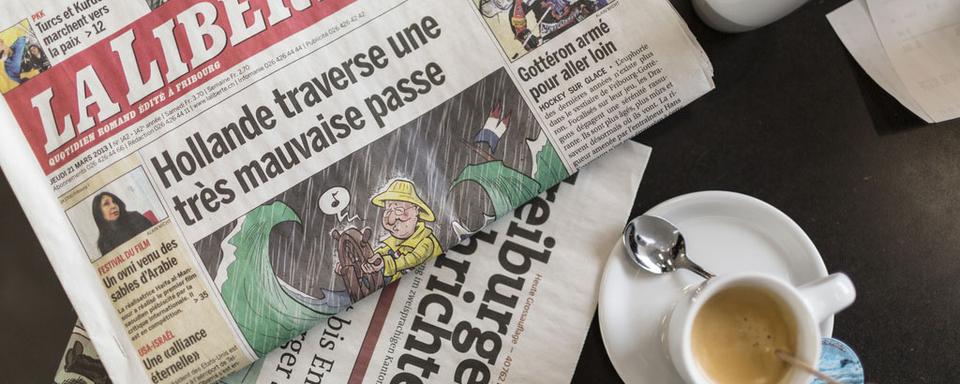 Tous les mercredis, un café fribourgeois propose de se réunir pour passer en revue les titres de la presse du jour. [Keystone - Gaetan Bally]