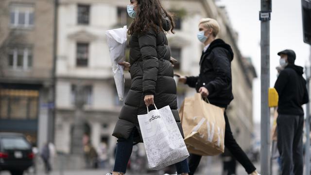 Des personnes masquées font des emplettes dans la Bahnhofstrasse à Zurich, le 27 novembre 2020. [Keystone - Gaetan Bally]