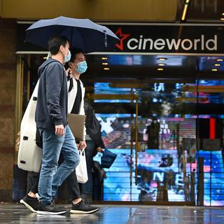Des passants devant le cinéma Cineworld de Leicester Square, à Londres, le 4 octobre 2020. [AFP - JUSTIN TALLIS]