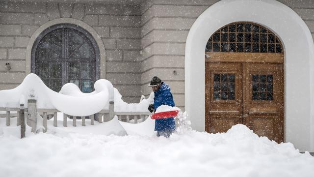 Un homme en train de déneiger à St-Moritz (GR) le samedi 5 décembre 2020. [Keystone - JEAN-CHRISTOPHE BOTT]