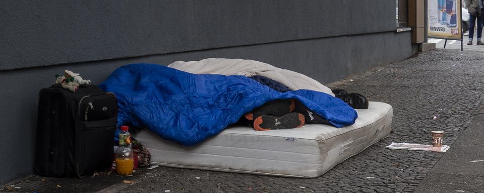 Deux personnes sans-abri dans une rue de Berlin. [Keystone - DPA/Paul Zinken]