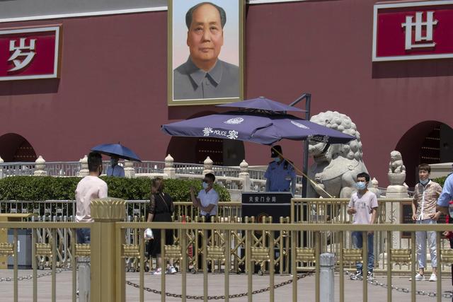 Du personnel de sécurité surveille les visiteurs vers la porte donnant sur la place Tiananmen, Pékin, le 4 juin 2020. [Keystone/AP Photo - Ng Han Guan]