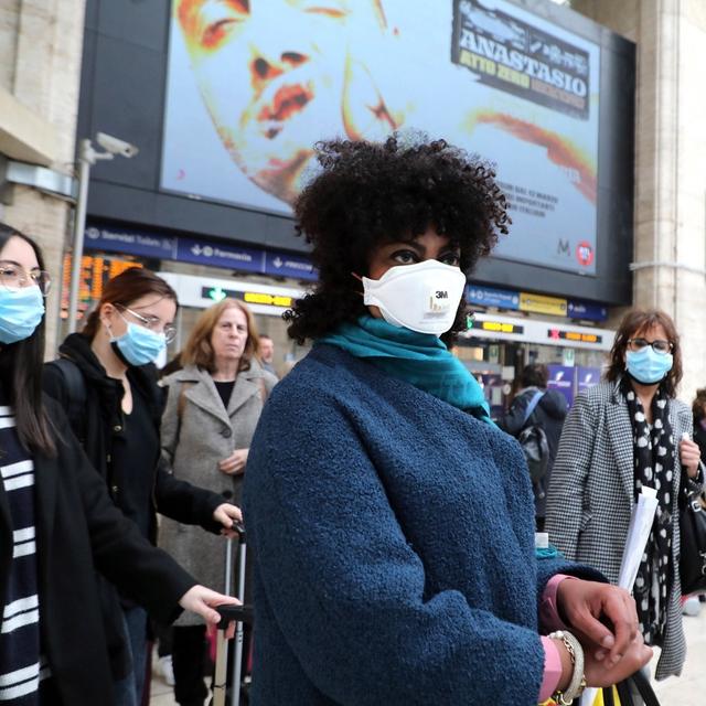 Des voyageurs portant des masques de protection à la gare centrale de Milan en Italie. [KEYSTONE - MATTEO BAZZI / EPA]