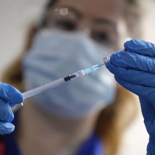 Une infirmière prépare une dose du vaccin de Pfizer-BioNTech contre le Covid-19. Londres, le 8 décembre 2020. [Keystone/AP photo - Frank Augstein, Pool]