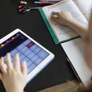 Une écolière utilise une tablette pour un exercice de mathématiques. [Keystone - Gaetan Bally]