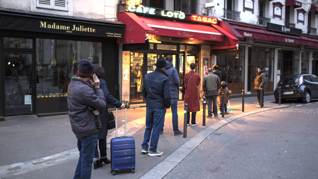 Des personnes font la queue à l'entrée d'un commerce parisien en respectant les distances. [AP/Keystone - Rafael Yaghobzadeh]
