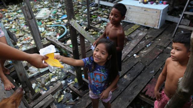 Les enfants d'un quartier pauvre de Manaus, au Brésil, reçoivent des masques de protection. [afp - Michael Dantas]