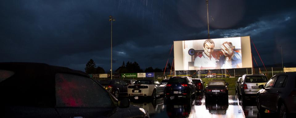 Dans le canton de Vaud, la cinquième édition du Cinéma Drive-In de Cossonay, s'est terminée par un succès. La pandémie de Coronavirus n'y est pas pour rien. [Keystone - Jean-Christophe Bott]