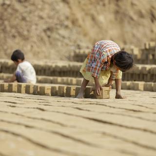 Des enfants travaillent pour une usine de briques aux alentours de Yangon, en Myanmar. [EPA/Keystone - Lynn Bo Bo]