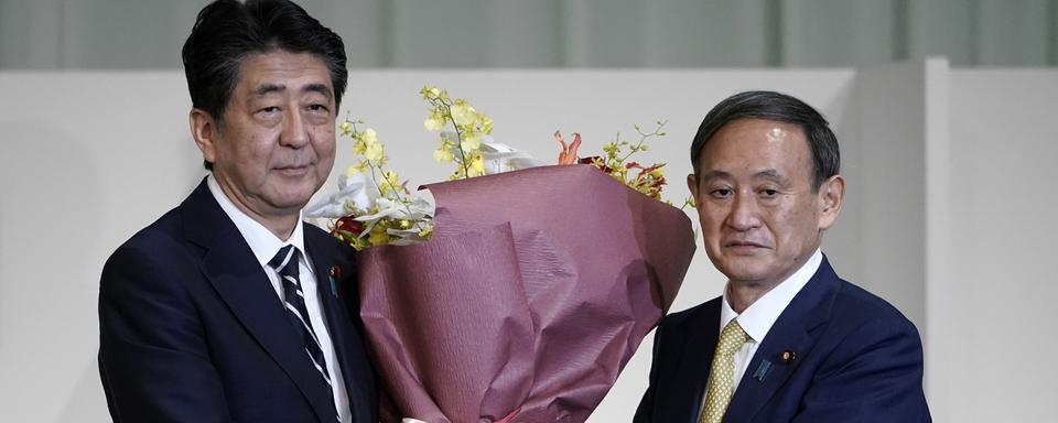 Shinzo Abe et Yoshihide Suga. [Keystone/AP Photo - Eugene Hoshiko]