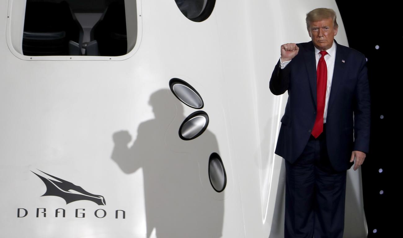 Le président américain, Donald Trump, pose devant la capsule Crew Dragon de l'entreprise privée SpaceX. [Keystone - Erik S. Lesser]