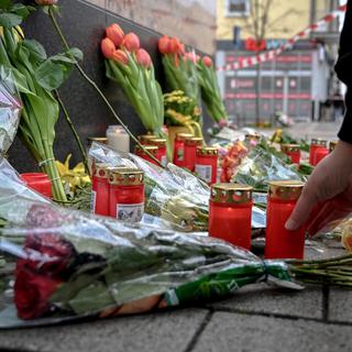 Des fleurs et bougies ont été déposées devant le bar où huit personnes ont été tuées à Hanau en Allemagne. [EPA/Keystone - Sascha Steinbach]
