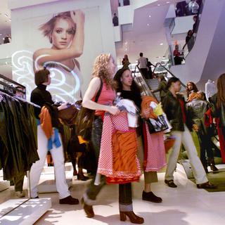 Shoppers carry armloads of clothes and accessories as they shop on the opening day of Swedish retailer's H & M store on New York's Fifth Ave., Friday afternoon March 31, 2000. From curious New Yorkers to European tourists, they piled into H&M's store on tony Fifth Avenue, combing through the racks filled with fashionable $9 shirts and $20 pairs of pants. The enthusiastic crowd offered a temporary distraction from troubles that beset H&M last week, when its chief executive quit and the company reported a 12 percent drop in projected quarterly profits [AP - Richard Drew]