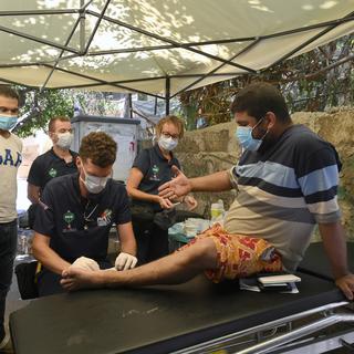 Un médecin des Pompiers Humanitaires Francais (PHF) soigne un blessé à Beyrouth. [EPA/Keystone - Wael Hamzeh]