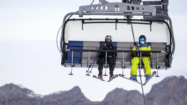 Des skieurs sur un télésiège au Titlis (UR) le 10 novembre 2020. [Keystone - Alexandra Wey]