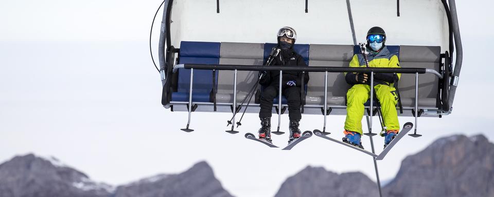 Des skieurs sur un télésiège au Titlis (UR) le 10 novembre 2020. [Keystone - Alexandra Wey]