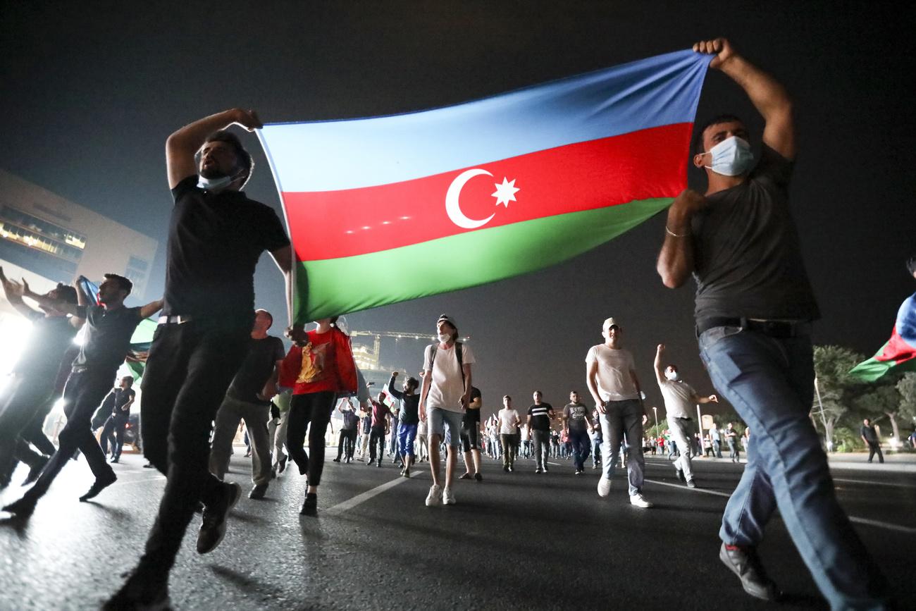 Des Azéris défilent dans les rues de Bakou lors d'une manifestation hostile à l'Arménie. [Keystone/AP - Aziz Karimov]