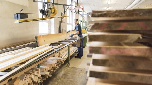 Un menuisier dans l'atelier de production d'équipement sportif Alder et Eisenhut à Ebnat-Kappel (SG). [Keystone - Christian Beutler]