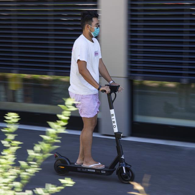 Un homme roule en trottinette éléctrique. [Keystone - Salvatore Di Nolfi]