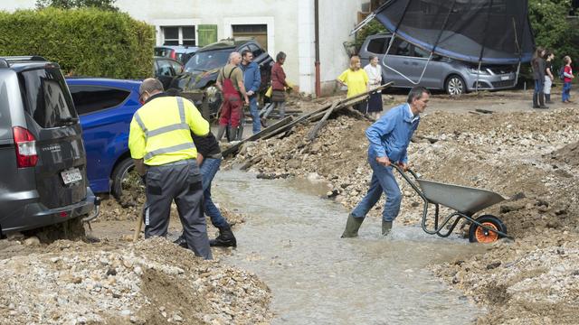 Les habitants collaborent et s'organisent à Villiers et Dombresson pour évacuer les gravats après les orages qui se sont abattus le 22 juin 2019. [Keystone - Laurent Gilliéron]