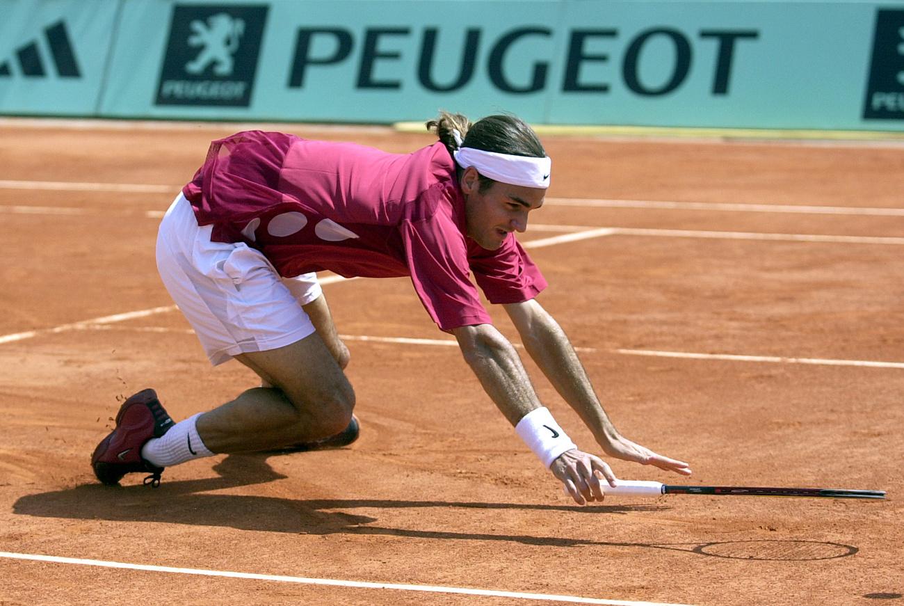 En allant chercher une balle au filet, Roger Federer trébuche - dans tous les sens du terme - devant Luis Horna. [AFP - Francois Mori]